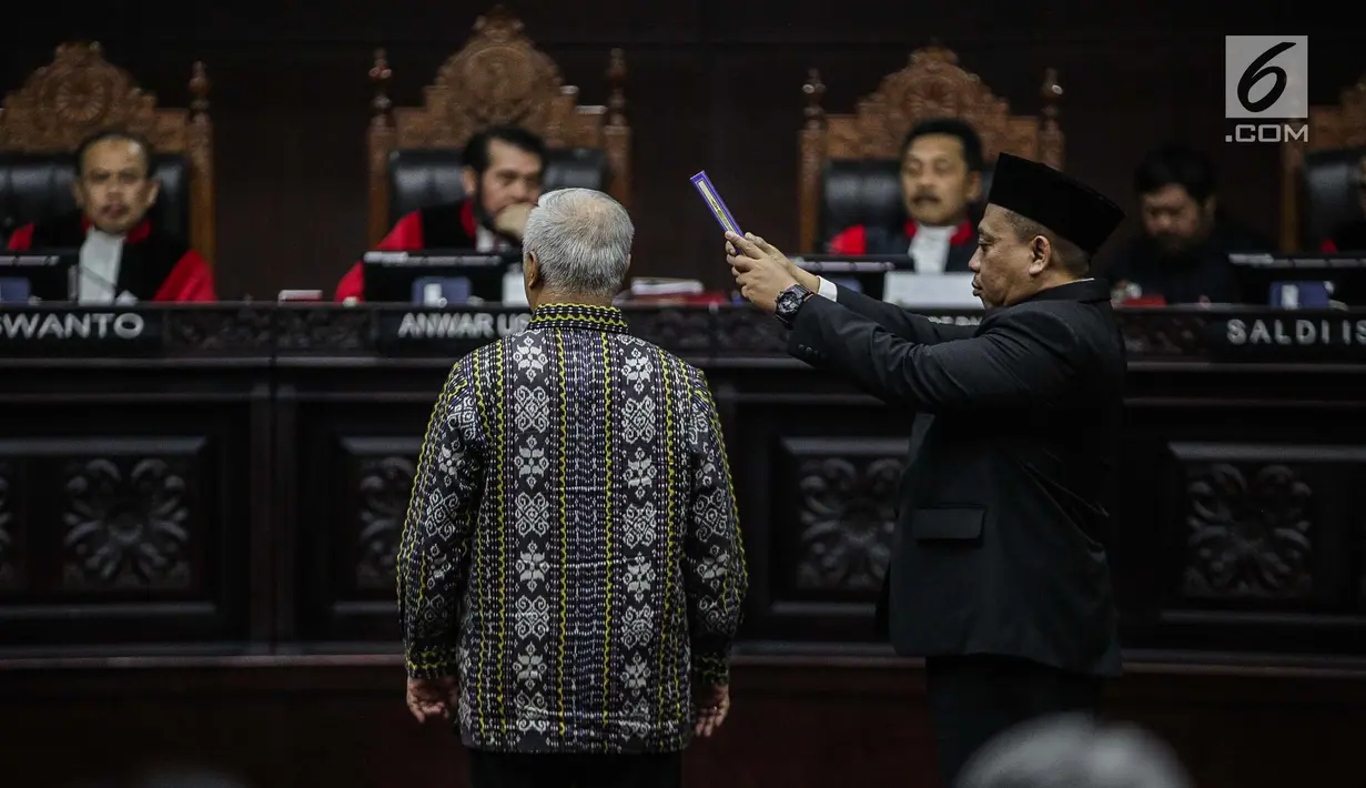 Marsudi Wahyu Kisworo, ahli yang dibawa oleh tim hukum KPU disumpah sebelum memberikan keterangan dalam sidang lanjutan sengketa Pilpres 2019 di Gedung MK, Jakarta, Kamis (20/6/2019). Sidang mendengarkan keterangan saksi dan ahli dari pihak termohon, yaitu KPU RI. (Liputan6.com/Faizal Fanani)