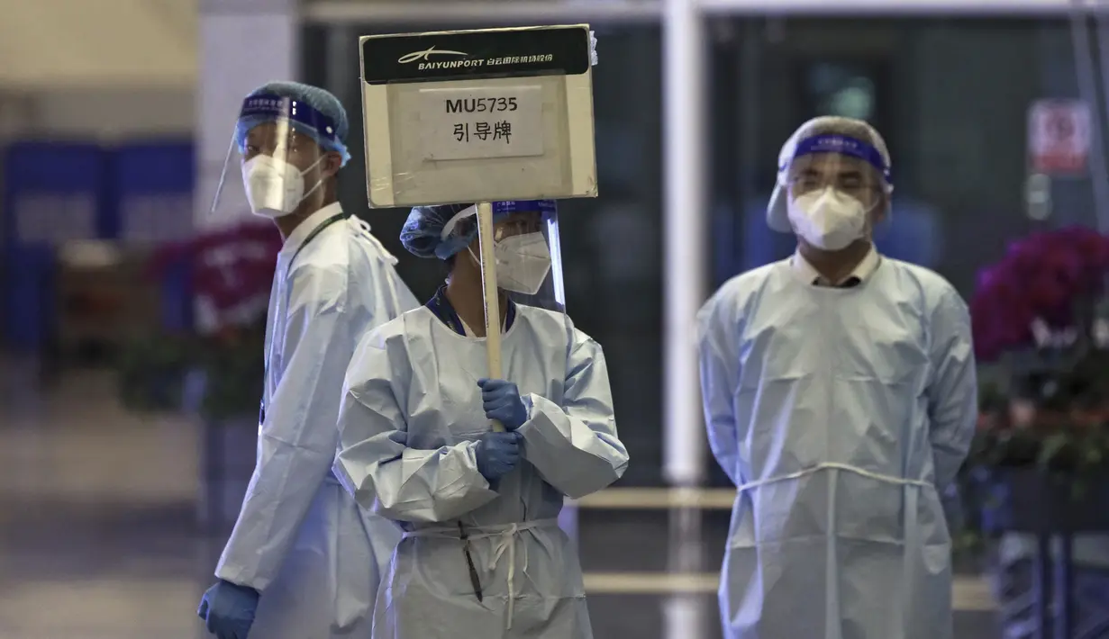 Petugas dari China Eastern memegang papan nama yang menunggu untuk memandu kerabat para korban menuju area tertutup, di Bandara Internasional Baiyun, Guangzhou, Senin (21/3/2022). Pesawat jatuh itu bertolak dari Kunming di Provinsi Yunnan menuju Guangzhou di Provinsi Guangdong. (Chinatopix Via AP)
