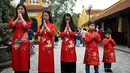 Sebuah keluarga Vietnam yang mengenakan pakaian tradisional Ao Dai berdoa pada hari pertama Tahun Baru Imlek atau perayaan Tet di Pagoda Tran Quoc, salah satu pagoda tertua di Hanoi pada Jumat (12/2/2021). Vietnam menyebut tahun baru Imlek dengan sebutan Tet Nguyen Dan. (Manan VATSYAYANA / AFP)