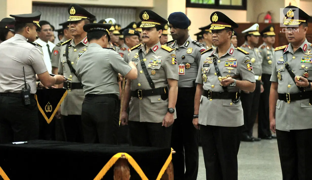 Kapolri Jenderal Tito Karnavian menyematkan tanda jabatan saat pelantikan dan serah terima Jabatan di Gedung Rupatama Mabes Polri, Selasa (5/9). Tito melantik lima kapolda baru dan menaikkan pangkat 11 pejabat tinggi Polri. (Liputan6.com/Helmi Afandi)