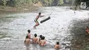 Anak-anak bermain air di aliran Sungai Ciliwung, Depok, Jawa Barat (30/5). Sungai Ciliwung kini menjadi tempat wisata alternative bagi masyarakat untuk bermain sekaligus menjaga kebersihan lingkungan. (Liputan6.com/Herman Zakharia)