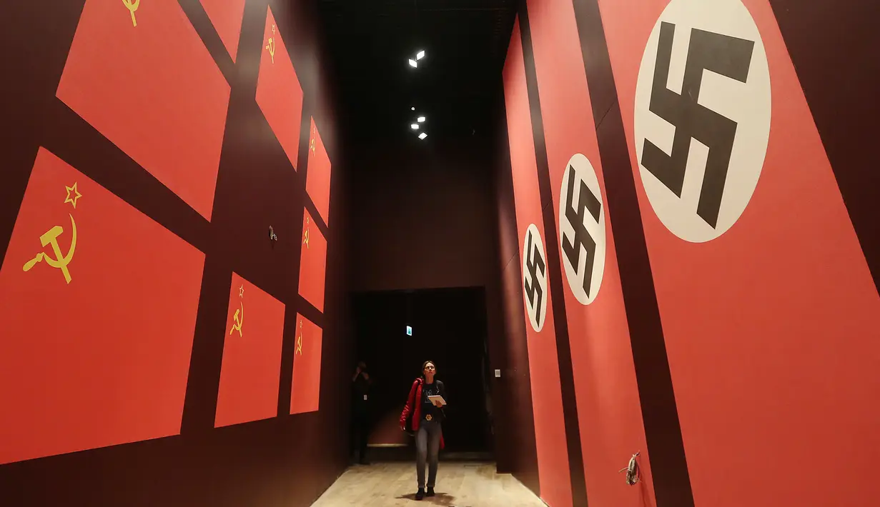 Pengunjung melintas dilorong bergambarkan bendera Nazi dan Soivet di Museum Perang Dunia 2 di Gdansk, Polandia, 23/1). Museum ini satu-satunya yang merekam sejarah Polandia saat Perang Dunia II. (AP/Czarek Sokolowski)