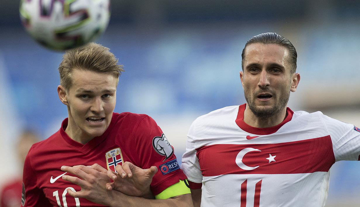 Gelandang Norwegia, Martin Odegaard (kiri) berebut bola dengan striker Turki, Yusuf Yazici dalam laga Kualifikasi Piala Dunia 2022 Zona Eropa Grup G di La Rosaleda Stadium, Malaga, Sabtu (27/3/2021). Norwegia kalah 0-3 dari Turki. (AFP/Jorge Guerrero)