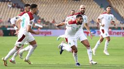 Penyerang Maroko Sofiane Boufal (kanan) melakukan selebrasi usai mencetak gol tendangan penalti ke gawang Mesir pada pertandingan perempat final Piala Afrika (CAN) 2021 di Stade Ahmadou Ahidjo di Yaounde (30/1/2022). Mesir menang atas Maroko 2-1. (AFP/Kenzo Tribouillard)