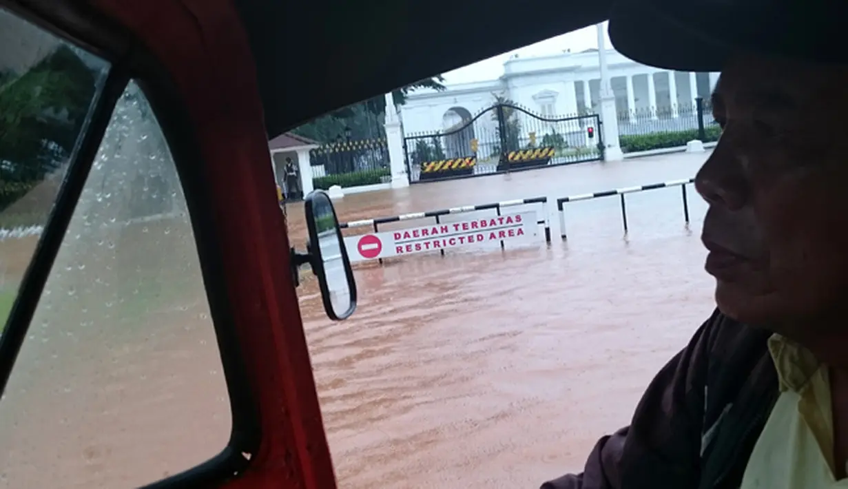 Kendaraan Bajaj saat melintasi di depan istana Negara yang terendam banjir, Jakarta, Senin (9/2/2015).(Antara Foto/Fanny Octavianus)