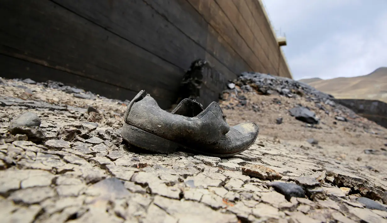 Sebuah sepatu terlihat di dasar Bendungan Ajuan Khota yang mengalami kering, di dekat La Paz, Bolivia, (17/11). Bendungan tersebut, salah satu tempat yang menyimpan cadangan air terbesar. (REUTERS/David Mercado)