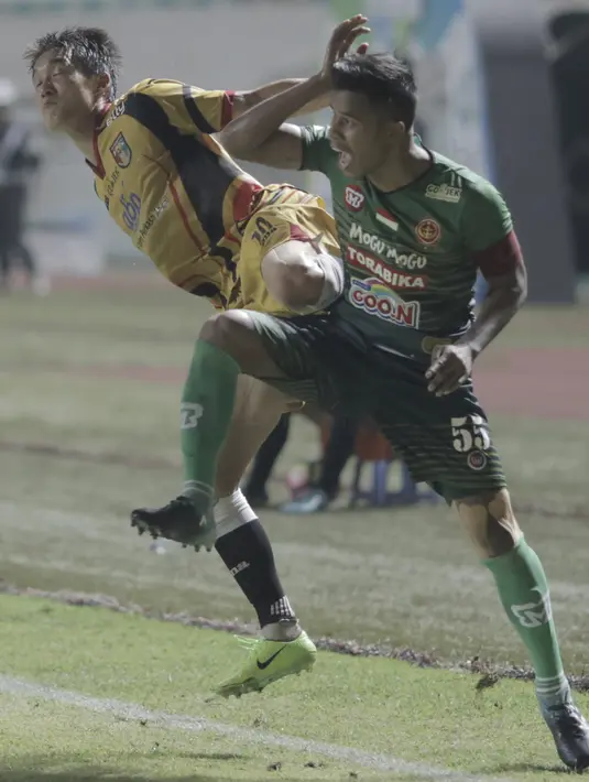 Ekspresi pemain PS TNI, Manahati Lestusen (kanan) saat berebut bola dengan pemain Mitra Kukar pada lanjutan Liga 1 2017 di Stadion Pakansari, Bogor (26/9/2017). PS TNI menang 2-1. (Bola.com/Firdhy Esterina)