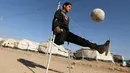 Seorang bocah bernama Jasim Abudllah bermain bola di kamp Debaga, di pinggiran Erbil, Irak (24/11). Meski hidup dengan satu kaki akibat terkena serangan udara, Jasim berusaha hidup seperti bocah normal lainya. (Reuters/Mohammed Salem)