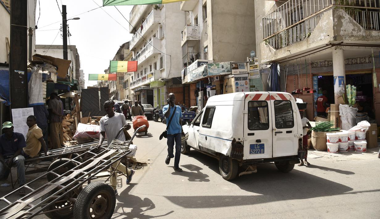 Bendera nasional Sengal digantung di dua sisi jalan sibuk Dakar (4/2/2022). Senegal akan bertanding melawan Mesir pada babak final Piala Afrika 2021 di Paul Biya stadium, Senin (7/2/2022) dini hari WIB besok. (AFP/Seyllou)
