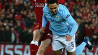 Pemain Manchester City Ilkay Gundogan berebut bola dengan pemain Liverpool Andy Robertson saat pertandingan Liga Champions di Anfield, Liverpool (4/4). Liverpool menang 3-0 atas Manchester City. (AFP Photo/Dave Thompson)