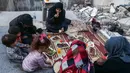 Keluarga Tareq Abu Ziad berbuka puasa di tengah reruntuhan rumah mereka yang hancur setelah serangan militer pasukan pemerintah dan sekutunya di Kota Ariha, Provinsi Idlib, Suriah, Senin (4/5/2020). Muslim Suriah melewati Ramadan tahun ini masih dalam kondisi perang. (AAREF WATAD/AFP)