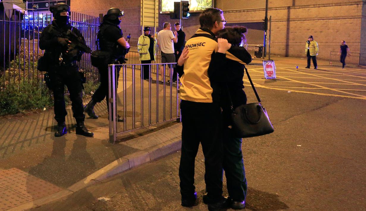 Sejumlah orang bereaksi menyusul ledakan yang terjadi di dalam arena konser penyanyi Ariana Grande di Manchester, Inggris, Senin (22/5). Bintang pop Ariana Grande dilaporkan dalam kondisi baik menyusul ledakan dalam konsernya itu. (Peter Byrne/PA via AP)