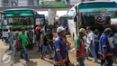 Pemudik berjalan di antara bus tujuan di Terminal Rawamangun, Jakarta, Minggu (15/7/2015). Sejumlah kota di Jawa Tengah seperti Kebumen, Solo, dan Purwokerto menjadi tujuan para pemudik yang berangkat dari terminal Rawamangun. (Liputan6.com/Faizal Fanani)