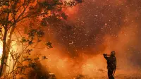 Seorang petugas pemadam kebakaran memadamkan api di Cordoba, Argentina (12/10/2020). Kebakaran hutan telah menghancurkan ribuan hektar di provinsi Cordoba, Argentina tahun ini, di tengah kekeringan dan suhu tinggi. (AP Photo/Nicolas Aguilera)