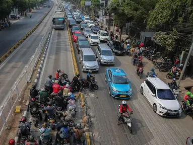 Sejumlah pemotor menerobos pembatas saat razia sterilisasi jalur Transjakarta di Jalan Buncit Raya, Mampang, Jakarta, Jumat (25/9/2015). Setiap harinya banyak pemotor yang nekat memasuki lajur busway yang semestinya steril. (Liputan6.com/Faizal Fanani)