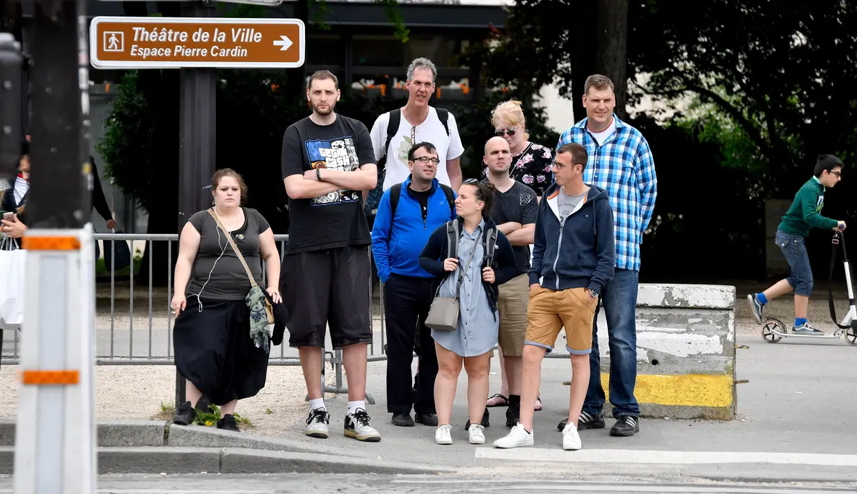 Sergey Ilin (2,26 meter), Dave Rasmussen (2,21 meter) dan Robert Steven (2,19 meter) menunggu untuk menyebrang jalan di Champs-Elysees Avenue, Paris, 1 Juni 2018. Belasan pria tertinggi di dunia bertemu pada akhir pekan di Paris. (AFP/GERARD JULIEN)