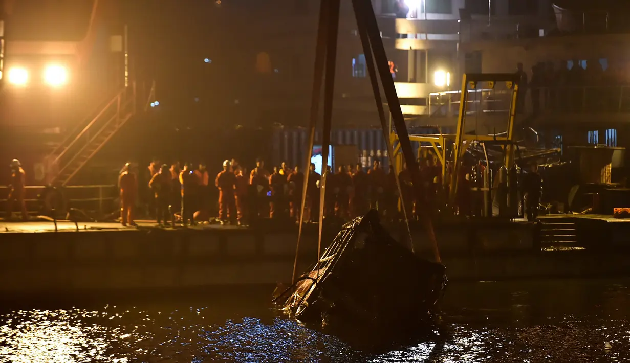 Sebuah crane mengevakuasi bus setelah jatuh dari jembatan ke Sungai Yangtze di Chongqing barat daya China (1/11). Bangkai bus beserta 9 jenazah baru bisa dievakuasi pada Selasa (31/10). (AFP Photo/Str)