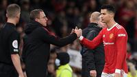 Striker Manchester United Cristiano Ronaldo berjabat tangan dengan manajer Interim Ralf Rangnick saat meninggalkan pertandingan dalam laga Liga Inggris melawan Burnley. MU menang 3-1 di Old Trafford, Jumat (31/12/2021) dini hari WIB. (Oli SCARFF / AFP)