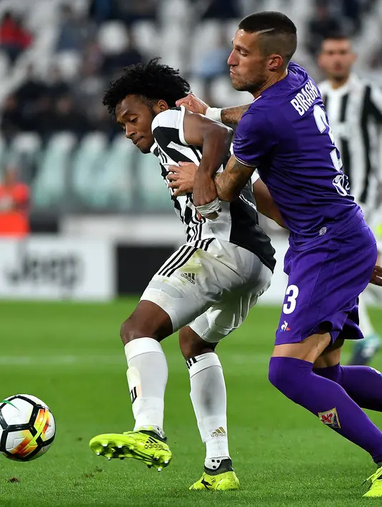 Pemain Juventus, Juan Cuadrado (kiri)  berusaha melewati adangan pemain Fiorentina, Cristiano Biraghi pada lanjutan Serie A di Allianz Stadium, Turin, (20/9/2017). Juventus menang 1-0. (AFP/Alberto Pizzoli)