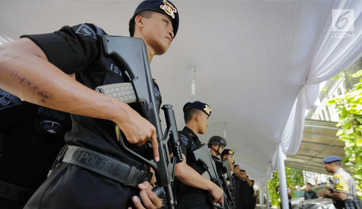 Personel Gegana dan K9 Polda Metro Jaya berbaris melakukan apel sebelum sterilisasi Gereja Katedral, Jakarta, Minggu (24/12). Petugas juga akan melakukan pengecekan barang bawaan jemaat ke dalam gereja. (Liputan6.com/Faizal Fanani)