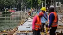 Pekerja mengerjakan proyek pemasangan sheet pile (turap) di kawasan Waduk Sunter Selatan, Jakarta, Senin (18/11/2019). Pemkot Jakarta Utara terus berupaya mempercantik kawasan Danau Sunter Selatan, salah satunya dengan pembangunan sheet pile atau turap. (Liputan6.com/Faizal Fanani)