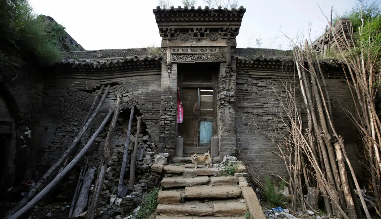 Batang pohon disusun untuk menahan dinding yang hampir runtuh di Kouquan kotapraja Datong, Provinsi Shanxi, Tiongkok, (1/8). (REUTERS/Jason Lee)