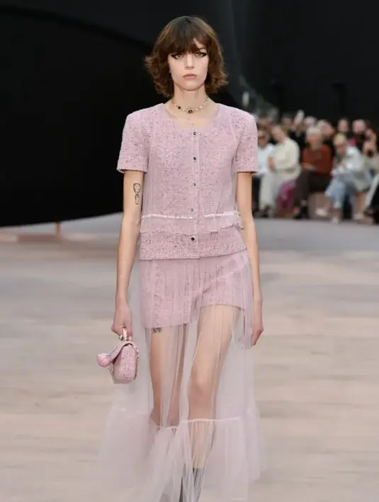 Elemen khas Rumah Mode ini ditata ulang melalui siluet yang ekstra. Jaket mini berbahan wol merah muda dipadukan dengan mini skirt, kian unik dengan aksen layer maxi dress berbahan tulle.  [Foto: Chanel.dok]
