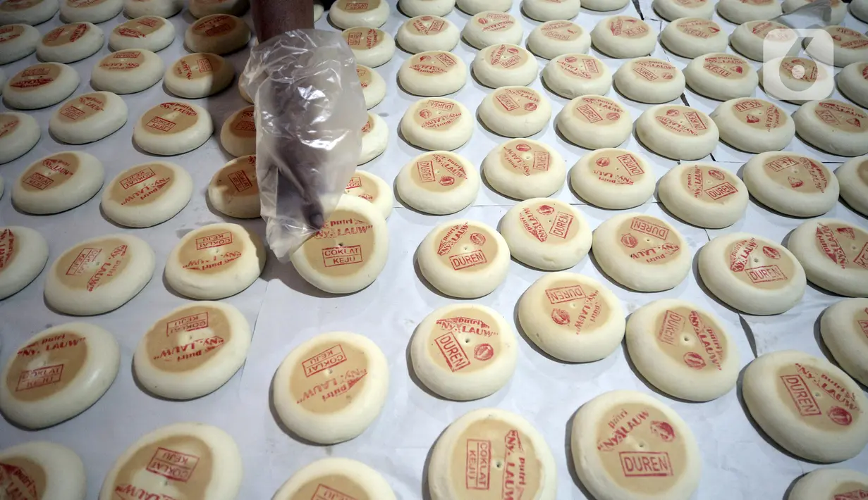 Pekerja menyelesaikan pembuatan kue bulan di Industri Rumahan Kue Bulan Putri Lauw, Pondok Sentul, Ciater, Tangerang Selatan, Selasa (10/11/2020). Pada masa pandemi sekarang, produksi kue tradisional khas Tionghoa tersebut menurun sesuai pesanan pembeli. (merdeka.com/Dwi Narwoko)