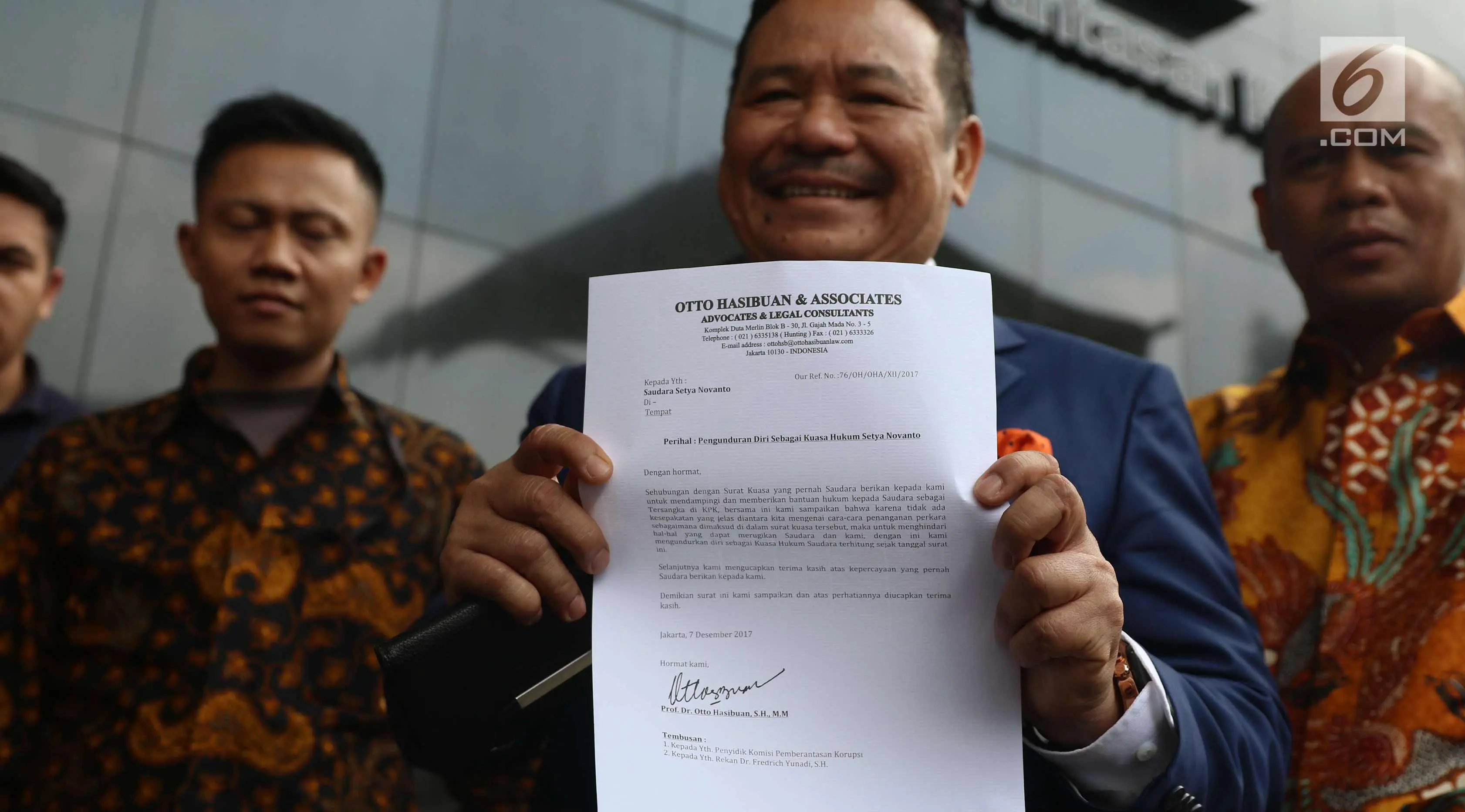 Pengacara Otto Hasibuan menunjukkan surat pengunduran diri sebagai kuasa hukum Setya Novanto di KPK, Jakarta, Jumat (8/12). Pengunduran Otto Hasibuan lantaran tak ada kecocokan dengan tim pengacara Setya Novanto yang lain. (Liputan6.com/Angga Yuniar)