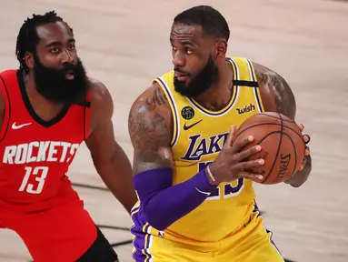 Pebasket LA Lakers, LeBron James, berebut bola dengan pebasket Houston Rockets, James Harden, pada semifinal playoff NBA di ESPN Wide World Sports, Orlando, Jumat (11/9/2020). LA Lakers menang 110-100 atas Houston Rockets. (AFP/Michael Reaves/Getty Images)