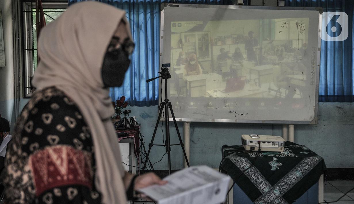 Suasana saat simulasi sekolah dengan model Kelas Hybrid di SMPN 255, Jakarta, Selasa (30/3/2021). Kelas Hybrid merupakan model sekolah tatap muka secara rotasi dengan jumlah kehadiran siswa 50 persen dengan kombinasi pembelajaran antara teknik pengajaran dan teknologi. (merdeka.com/Iqbal S Nugroho)