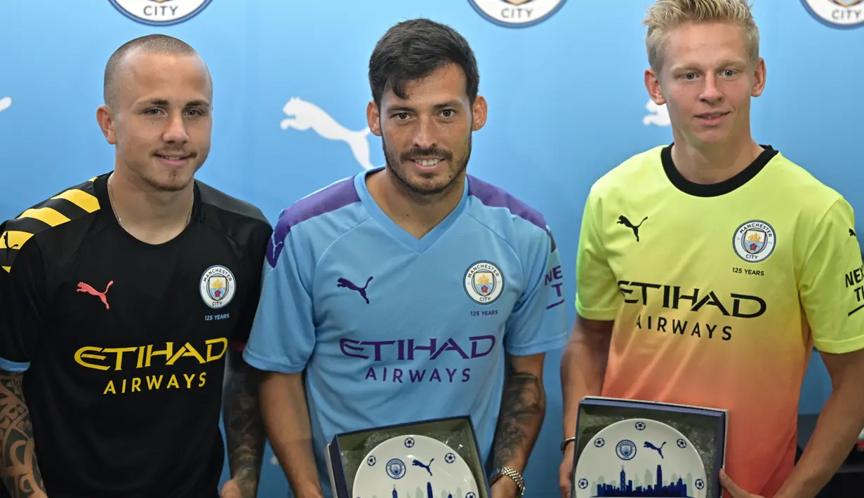 Pemain Manchester City David Silva, Angelino dan Oleksandr Zinchenko foto bersama selama acara promosi di Hong Kong (23/7/2019). The Citizens akan menghadapi Kitchee SC dalam laga uji cobadi Hong Kong Stadium pada 24 Juli 2019. (AFP Photo/Anthony Wallace)