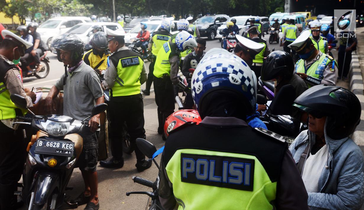 Polisi lalu lintas menggelar razia atau Operasi Patuh Jaya 2018 di Jalan DI Panjaitan, Jakarta Timur, Jumat (27/4). Khusus untuk Operasi Patuh Jaya 2018, para polantas akan memburu mereka yang menggunakan ponsel sambil berkendara (Merdeka.com/Imam Buhori)