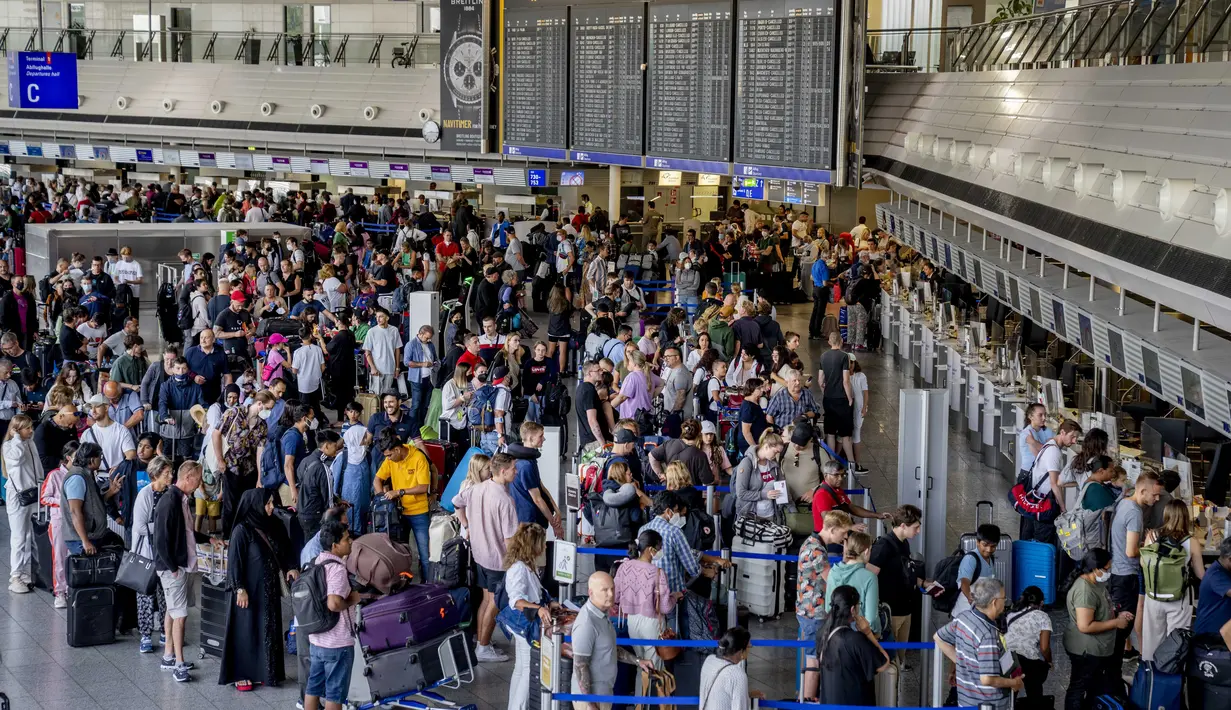 Penumpang mengantri di konter check-in di bandara internasional di Frankfurt, Jerman, Rabu (27/7/2022). Maskapai Jerman, Lufthansa telah membatalkan lebih dari 1.000 penerbangan. Pembatalan dilakukan imbas dari mogok kerja seluruh staf daratnya. (AP Photo/Michael Probst)