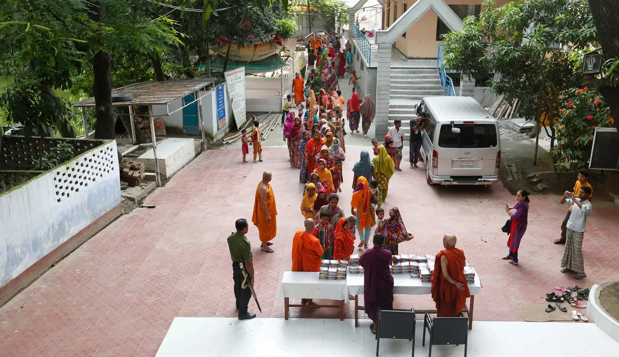 Sejumlah biksu memberikan makanan untuk berbuka puasa Ramadan kepada umat muslim yang kurang mampu di wihara Budha di Dhaka, Bangladesh (9/6). Hal ini tidak terjadi pada tahun ini saja, tetapi dilakukan setiap tahun di bulan Ramadan. (AP Photo/A.M. Ahad)