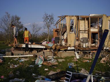 Aiden Locobon (kiri) dan Rogelio Paredes melihat-lihat sisa-sisa rumah keluarga mereka yang hancur akibat hantaman Badai Ida di Dulac, Louisiana, Sabtu (4/9/2021). Jumlah korban tewas akibat Badai Ida di negara bagian Louisiana, AS, pada Sabtu (4/9) bertambah menjadi 12 orang. (AP Photo/John Locher)
