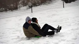 Pasangan bermain salju di Central Park di New York, (14/3). NWS menetapkan status darurat untuk negara bagian New York dan New Jersey yang terancam dilanda badai salju. (AFP Photo/Jewel Samad)