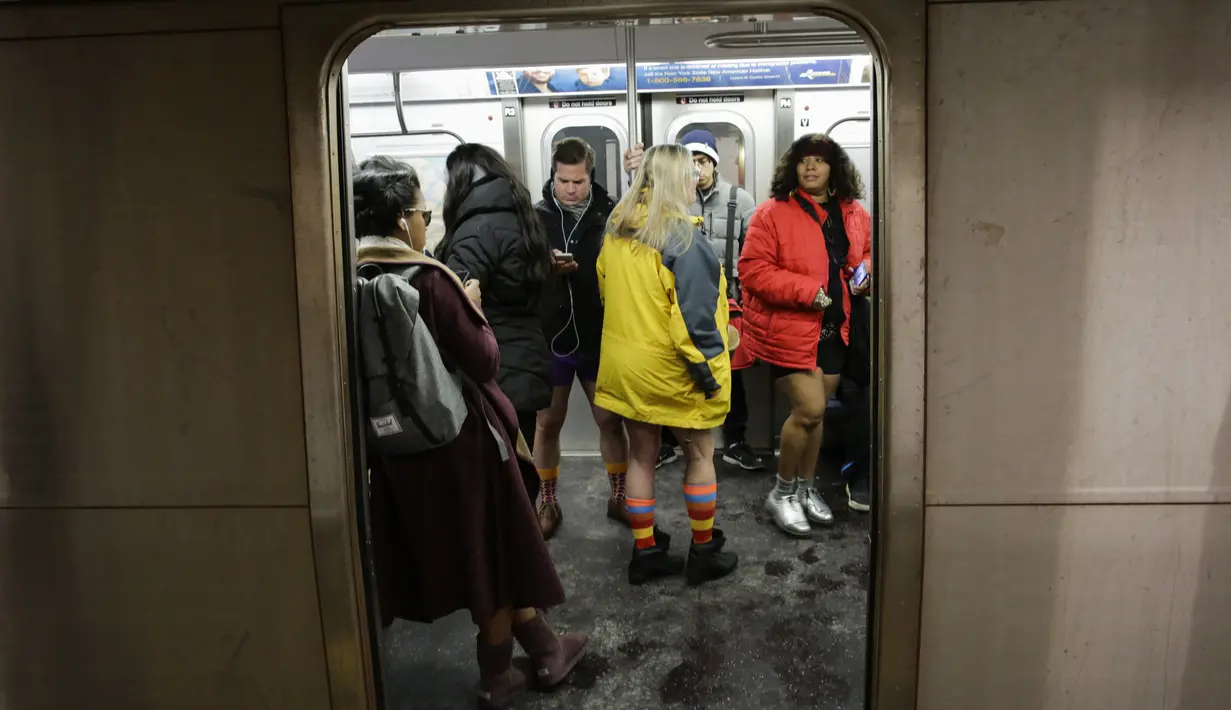 Penumpang menaiki kereta bawah tanah tanpa mengenakan celana pada No Pants Subway Ride di New York City, Minggu (7/1). Mereka berpartisipasi dalam Hari Tanpa Celana di Kereta di tengah udara yang sedang dingin. (EDUARDO MUNOZ ALVAREZ/GETTY IMAGES/AFP)