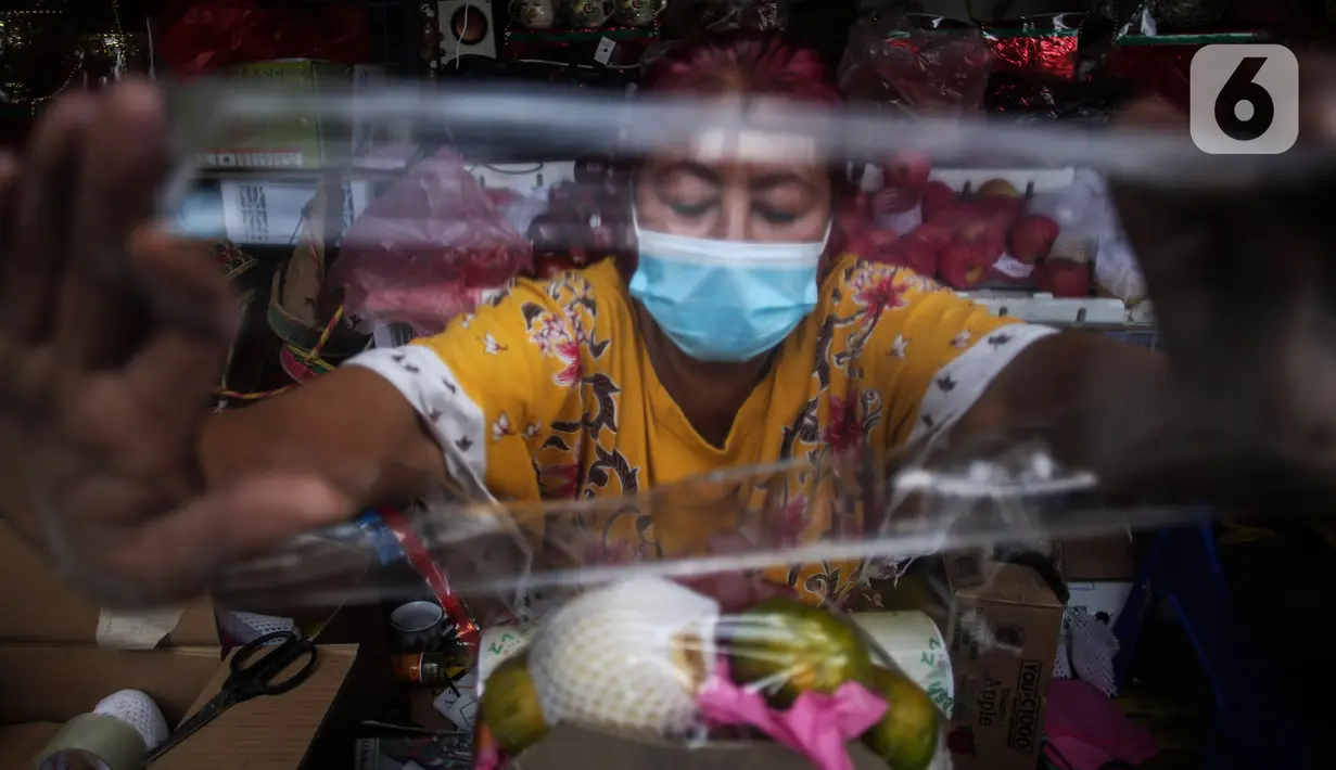 Surayem (58) menyiapkan parcel buah dan vitamin ditoko buah miliknya di Jalan Barito, Jakarta, Minggu (11/7/2021).  Surayem mengaku omset menjual parcel yang dijual secara online meningkat drastis hampir 100 persen dalam sepekan terakhir ini. (Liputan6.com/Johan Tallo)