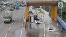 Sejumlah kendaraan melintasi Gerbang Tol Karang Tengah Barat 2 yang masih terendam banjir, Tangerang, Banten, Kamis (2/1/2020). Banjir setinggi betis orang dewasa masih menggenangi Gerbang Tol Karang Tengah Barat 2. (Liputan6.com/Angga Yuniar)