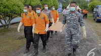 Tim SAR gabungan membawa tandu untuk memindahkan jenazah penumpang Pesawat AirAsia QZ8501 dari KRI Banda Aceh menggunakan helikopter Basarnas tiba di Lanud Iskandar Pangkalan Bun, Kalteng, Rabu (7/1/2015). (Liputan6.com/Andrian M Tunay)