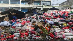 Krisis ini diakibatkan penutupan Tempat Pembuangan Akhir (TPA) sampah di Cipeucang di Serpong, Tangerang Selatan. Tampak dalam foto, pemulung saat berada di antara tumpukan sampah pada salah satu ruas jalan di kawasan Pasar Manggis, Ciputat, Tangerang Selatan, Senin (15/12/2025). (merdeka.com/Arie Basuki)