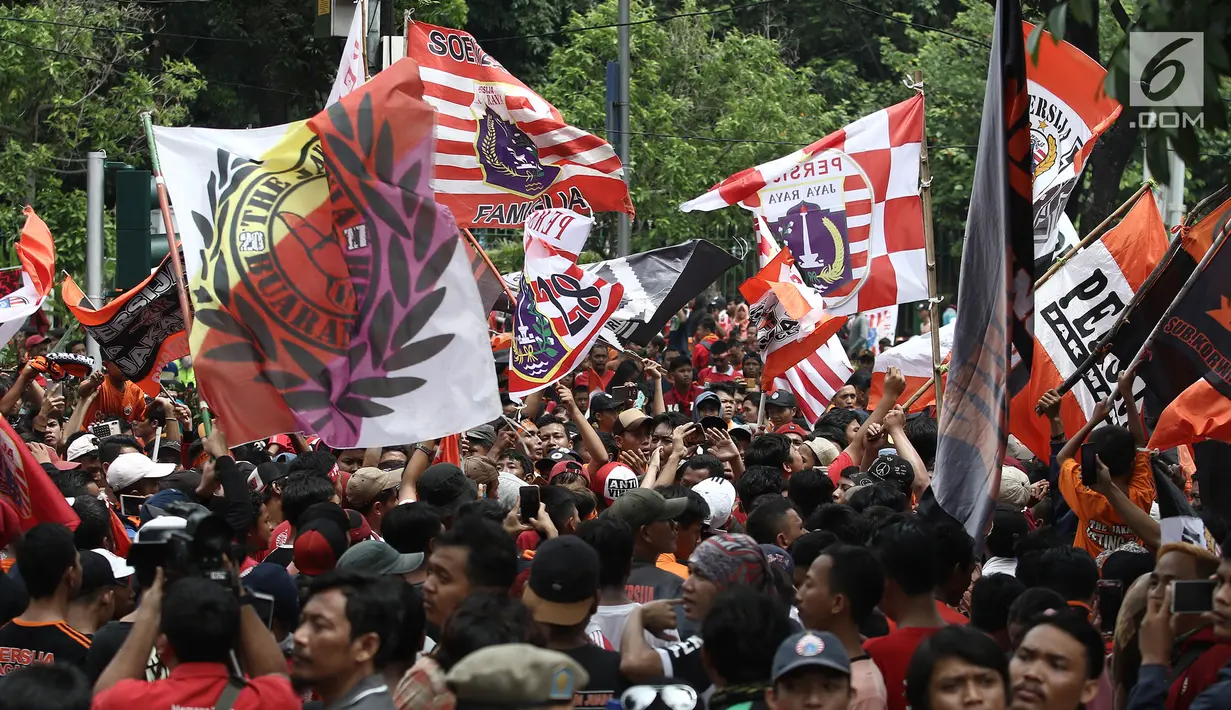 Jakmania mengibarkan bendera Persija saat penyerahan piala Liga I di depan Balai Kota, Jakarta, Sabtu (15/12). Persija kembali meraih juara Liga Indonesia setelah 17 tahun. (Liputan6.com/Herman Zakharia)