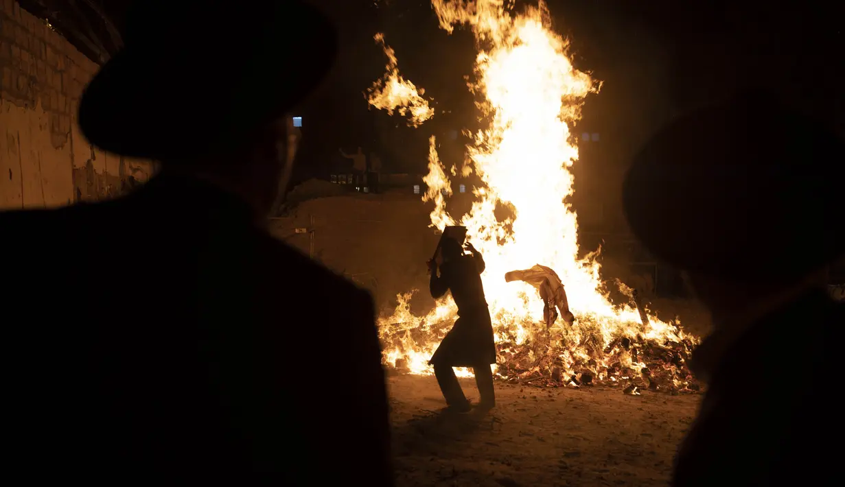 Pemuda Yahudi Ultra-Ortodoks berdiri di samping api unggun selama hari libur Yahudi perayaan Lag Ba'Omer di Bnei Brak, Israel, Kamis (29/4/2021). Liburan Lag Ba'Omer, menandai berakhirnya wabah yang dikatakan telah membinasakan orang Yahudi selama zaman Romawi. (AP Photo/Sebastian Scheiner)