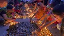 Orang-orang menyalakan lampu di tepi sungai Saryu di Ayodhya, India, Rabu (3/11/2021). Lebih dari 900.000 lampu minyak dinyalakan dan terus menyala selama 45 menit saat kota Ayodhya mempertahankan Rekor Dunia Guinness sebagai bagian dari perayaan festival Diwali. (AP Photo/Rajesh Kumar Singh)