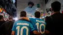 Orang-orang berkumpul di depan mural raksasa Diego Maradona saat mereka memberi penghormatan dan memperingati mendiang legenda sepak bola di hari ulang tahunnya di Naples, Italia, 30 Oktober 2022. Legenda sepak bola asal Argentina, Diego Armando Maradona yang lahir pada 30 Oktober 1960 meninggal pada 25 November 2020. (Alessandro Garofalo/LaPresse via AP)