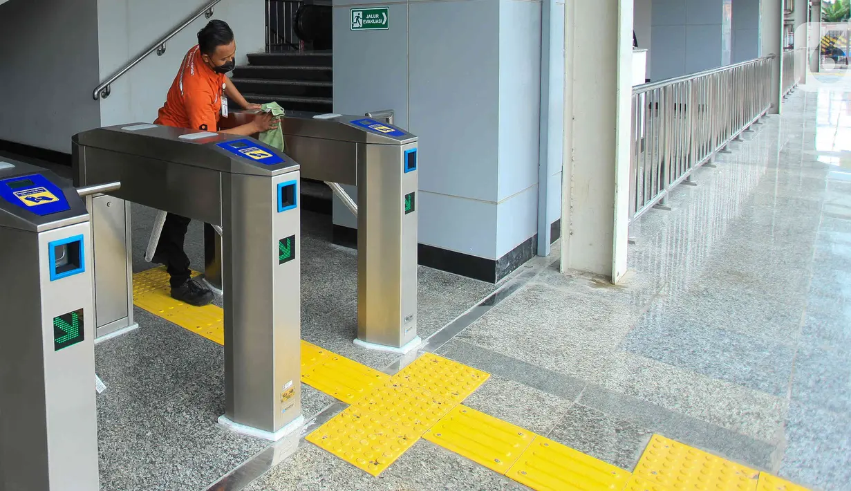 Petugas membersihkan mesin gate karcis elektronik di Stasiun Matraman, Jakarta, Senin (13/6/2022). Sebagai persiapan pengoperasian Stasiun Matraman, telah dilakukan uji coba perjalanan KRL, uji coba sistem persinyalan, serta uji coba prasarana-prasarana operasional perjalanan kereta api lainnya. (Liputan6.com/Herman Zakharia)