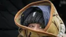 Seorang pengungsi terbungkus selimut yang melarikan diri dari perang Ukraina tiba di perbatasan di Palanca, Moldova, Senin (7/3/2022). Rusia mengumumkan lagi gencatan senjata dan beberapa koridor kemanusiaan untuk memungkinkan warga sipil melarikan diri dari Ukraina. (AP Photo/Sergei Grits)