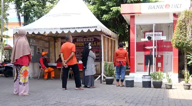 Warga antre untuk melakukan penarikan uang bantuan sosial tunai (BST) di ATM Bank DKI di Jakarta, Selasa (20/7/2021). Pemprov DKI Jakarta resmi mencairkan BST kepada warga DKI Jakarta. (Liputan6.com/Angga Yuniar)