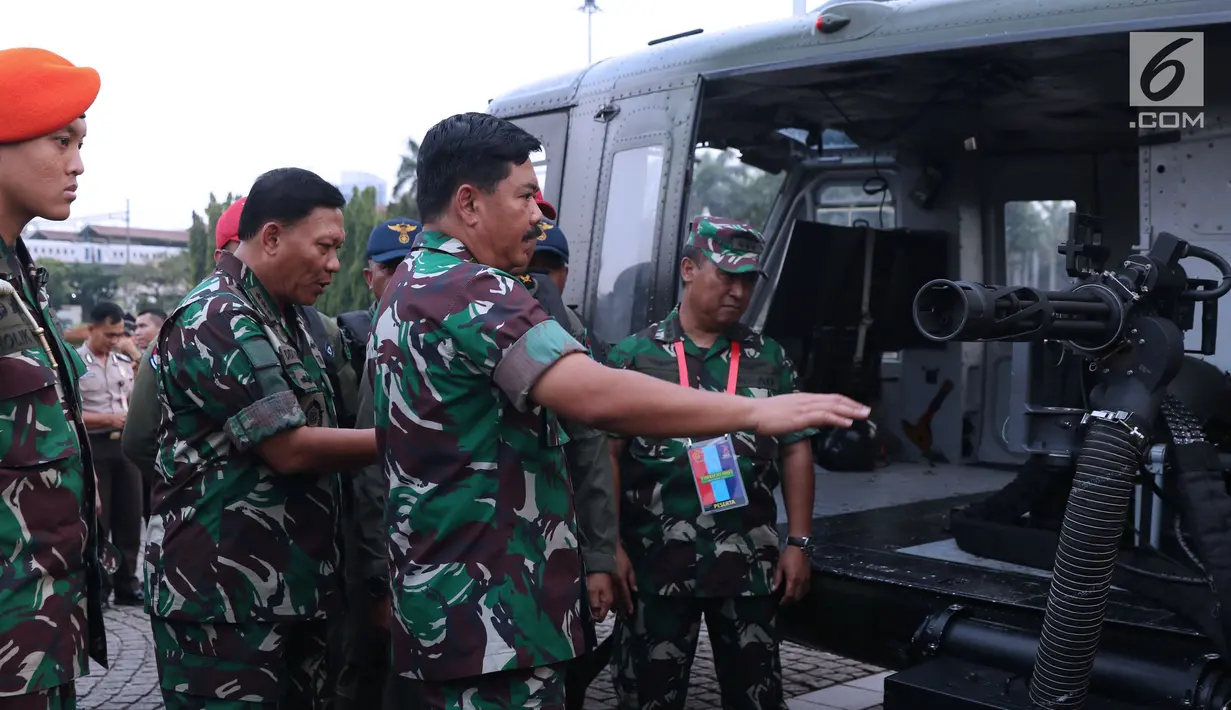 Panglima TNI, Marsekal TNI Hadi Tjahjanto saat meninjau senjata yang ada di helikopter pada pameran Alat Utama Sistem Persenjataan TNI di Kawasan Monas, Jakarta, Kamis (27/9). Pameran ini berlangsung hingga 29 September. (Liputan6.com/Helmi Fithriansyah)
